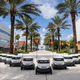 A fleet of Starship Technologies food delivery robots in front of palm trees on a college campus